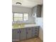 Features a double basin sink, laminate countertops, and painted gray cabinets with matte black hardware at 530 S Alma School Rd # 75, Mesa, AZ 85210