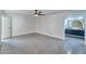 Spacious bedroom with light gray tile flooring, modern ceiling fan, and arched doorway at 5324 E Hillery Dr, Scottsdale, AZ 85254