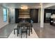 Dining area showcasing a modern bar with shelving, black cabinets, and stainless steel refrigerator at 5324 E Hillery Dr, Scottsdale, AZ 85254