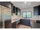 Modern kitchen with stainless steel appliances, marble countertops, and sleek cabinetry at 5324 E Hillery Dr, Scottsdale, AZ 85254