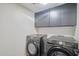 Modern laundry room featuring a sleek Samsung washer and dryer set and storage at 5324 E Hillery Dr, Scottsdale, AZ 85254