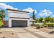 Modern stucco home featuring a two-car garage, desert landscaping, and a spacious driveway on a sunny day at 5435 E Cambridge Ave, Phoenix, AZ 85008