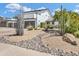 Contemporary home featuring desert landscaping, two-car garage, and stucco exterior under a bright blue sky at 5435 E Cambridge Ave, Phoenix, AZ 85008
