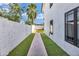Side yard featuring a brick walkway with artificial grass and block wall at 5435 E Cambridge Ave, Phoenix, AZ 85008