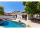 Inviting backyard pool with rock features, lush landscaping, and a tranquil setting at 5909 E Aire Libre Ln, Scottsdale, AZ 85254