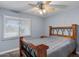 Tranquil bedroom with a wooden bed frame, a large window, and a ceiling fan at 6550 W Wolf St, Phoenix, AZ 85033