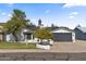 Charming single-story home with mature landscaping and a gray two-car garage door at 6550 W Wolf St, Phoenix, AZ 85033
