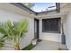 Stylish entryway with white textured walls, palm tree in pot and gray trim at 6550 W Wolf St, Phoenix, AZ 85033