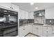 Bright kitchen with white cabinets, granite counters, stainless oven, and decorative backsplash at 6550 W Wolf St, Phoenix, AZ 85033