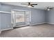 Spacious living room with a bay window and neutral carpet, lit by dual ceiling fans at 6550 W Wolf St, Phoenix, AZ 85033