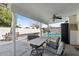 Covered patio with fan, table and chairs overlooking the swimming pool area at 6550 W Wolf St, Phoenix, AZ 85033