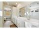 Bright bathroom featuring a double sink vanity with elegant cabinetry, a large mirror, and walk-in shower at 6954 W Maya Way, Peoria, AZ 85383
