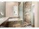 Luxurious bathroom with a glass-enclosed shower and a deep soaking tub with stone detailing at 7400 E Gainey Club Dr # 203, Scottsdale, AZ 85258