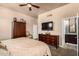 This bedroom boasts a television, wooden furniture, and a private entry to the bathroom at 7400 E Gainey Club Dr # 203, Scottsdale, AZ 85258