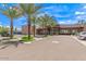Exterior view of parking lot with lush landscaping, palm trees, and the building's entrance at 7400 E Gainey Club Dr # 203, Scottsdale, AZ 85258