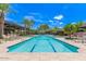 Resort-style swimming pool surrounded by palm trees and greenery with plenty of seating and lounge chairs at 7400 E Gainey Club Dr # 203, Scottsdale, AZ 85258
