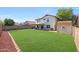 Large backyard featuring a manicured lawn, a storage shed, and block fence for privacy at 7658 W Boca Raton Rd, Peoria, AZ 85381