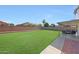 Expansive backyard with lush green grass and a covered patio perfect for outdoor entertaining at 7658 W Boca Raton Rd, Peoria, AZ 85381