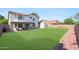 Spacious backyard featuring green grass, privacy fence, storage shed, and covered patio area at 7658 W Boca Raton Rd, Peoria, AZ 85381