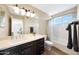 Bright bathroom with a double vanity, tiled floors, and a shower-tub combination at 7658 W Boca Raton Rd, Peoria, AZ 85381