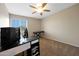 Carpeted bedroom with a desk area, a ceiling fan, and bright window light at 7658 W Boca Raton Rd, Peoria, AZ 85381