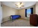 This bedroom features carpeted floors, a ceiling fan, and a large window with curtains at 7658 W Boca Raton Rd, Peoria, AZ 85381