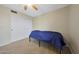 This bedroom features carpeted floors, a ceiling fan, and closet with sliding doors at 7658 W Boca Raton Rd, Peoria, AZ 85381