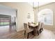 Stylish dining room with wood-look tile, pendant lights, view to the living area and an expansive backyard at 7658 W Boca Raton Rd, Peoria, AZ 85381