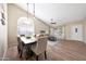 Elegant dining area featuring wood-look tile floors, stylish pendant lighting, and a view into the living room at 7658 W Boca Raton Rd, Peoria, AZ 85381