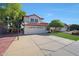 Well-maintained two-story home featuring a red tile roof, spacious driveway with basketball hoop, and tidy front lawn at 7658 W Boca Raton Rd, Peoria, AZ 85381