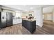 An open kitchen boasts tile floors, stainless steel appliances, and an island with granite countertops at 7658 W Boca Raton Rd, Peoria, AZ 85381