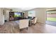 A well-lit living room boasts tile floors, comfortable seating, a modern entertainment center, and a sliding glass door at 7658 W Boca Raton Rd, Peoria, AZ 85381