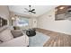 Inviting living room featuring wood-look tile floors, a ceiling fan, and staircase that leads to the second floor at 7658 W Boca Raton Rd, Peoria, AZ 85381