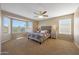Spacious main bedroom with a ceiling fan, large windows and neutral-toned carpet at 7658 W Boca Raton Rd, Peoria, AZ 85381