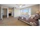 Bright main bedroom with a large bay window, carpet and an open doorway to the bathroom at 7658 W Boca Raton Rd, Peoria, AZ 85381