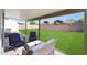 Covered patio with comfortable seating and hanging plants overlooking the manicured backyard at 7658 W Boca Raton Rd, Peoria, AZ 85381