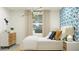Charming bedroom with a bed, unique light fixture, and a colorful, patterned accent wall at 9541 W Pinchot Ave, Phoenix, AZ 85037