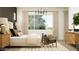 Cozy bedroom with a large window, neutral tones, and two comfortable chairs at 9633 W Monterey Way, Phoenix, AZ 85037