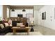Cozy living room featuring a comfortable couch, stylish décor, and an open-concept design leading to the kitchen at 9633 W Monterey Way, Phoenix, AZ 85037