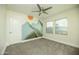 Neutral bedroom with a ceiling fan, two windows, and mountain scene wall decor at 1512 E Cypress St, Phoenix, AZ 85006