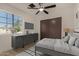 Cozy bedroom featuring a ceiling fan, dresser, and large window offering plenty of natural light at 1610 N Apache Dr, Chandler, AZ 85224