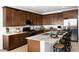 Kitchen island with dark wood cabinets and granite countertops, and stainless steel appliances at 17382 W Artemisa Ave, Surprise, AZ 85387