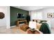 Modern living room featuring a green accent wall, stylish decor, and lots of natural light at 17382 W Artemisa Ave, Surprise, AZ 85387