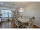 A stylish dining room featuring hardwood floors, a crystal chandelier, and plantation shutters at 17770 N 66Th Ln, Glendale, AZ 85308