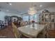 Open-plan dining area featuring a crystal chandelier, hardwood floors, and bright windows at 17770 N 66Th Ln, Glendale, AZ 85308