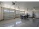 Spacious three-car garage with tables and chairs for multiple uses at 17770 N 66Th Ln, Glendale, AZ 85308