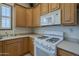 Close-up of the kitchen with white appliances and light cabinetry, and lots of natural light at 17770 N 66Th Ln, Glendale, AZ 85308