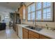Bright kitchen with light cabinetry, stainless sink, and tile flooring, seamlessly integrated with the living area at 17770 N 66Th Ln, Glendale, AZ 85308
