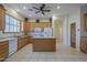 A spacious kitchen with light wood cabinets, a central island, and tile flooring at 17770 N 66Th Ln, Glendale, AZ 85308