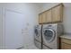 Functional laundry room with cabinets and modern washer and dryer units at 17770 N 66Th Ln, Glendale, AZ 85308
